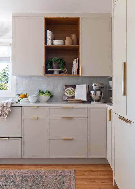 Custom kitchen cabinetry with open wood shelving and brass hardware