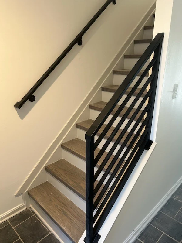 Modern black metal handrail and stair railing on a wood staircase